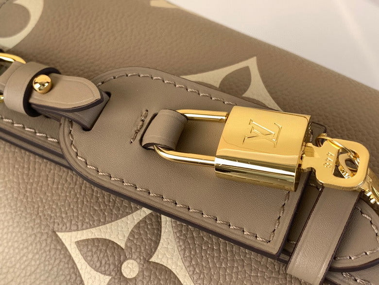 Close-up of a gray leather bag with a gold lock featuring a brand logo.